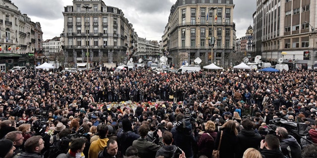 People observe a minute of silence at the Place de la Bourse in the center of Brussels, Wednesday, March 23, 2016. Bombs exploded yesterday at the Brussels airport and one of the city's metro stations Tuesday, killing and wounding scores of people, as a European capital was again locked down amid heightened security threats. (AP Photo/Martin Meissner)