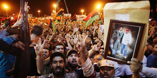 Monday: People celebrate the capture in Tripoli of Muammar al-Qaddafi's son and one-time heir apparent, Seif al-Islam, at the rebel-held town of Benghazi, Libya. The celebration was premature, however, as Seif al-Islam appeared in Tripoli Monday night to corral regime supporters.