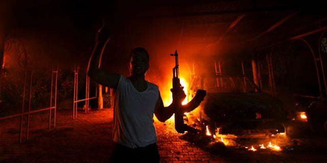 Sept. 11, 2012: A protester reacts as the U.S. Consulate in Benghazi is seen in flames. (Reuters)