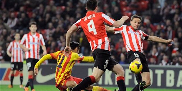 El brasileño Neymar, del Barcelona, a la izquierda, intenta anotar entre los jugadores del Athletic de Bilbao Aymeric Laporte y Carlos Gurpegui, a la derecha, durante un partido de la liga española en San Mamés, en Bilbao, España, el domingo 1 de diciembre de 2013. El Barcelona perdió 1-0. (AP Foto/Alvaro Barrientos)