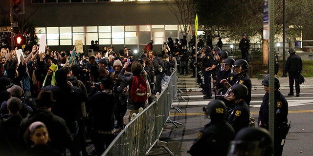 Protesters chant in front of a police line outside Berkeley Police Department headquarters during a march against the New York City grand jury decision not to indict in the death of Eric Garner, in December 2014.