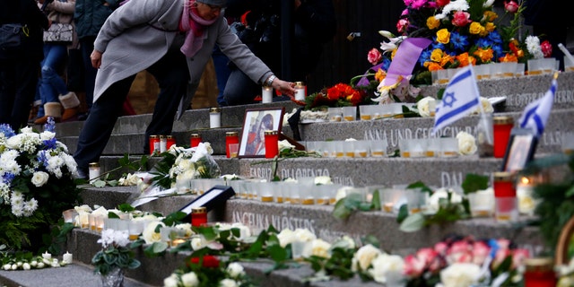 A woman lights a candle at the memorial at the site of last year's truck attack in a Christmas market, which killed 12 people and injured many others, at Breitscheidplatz square in Berlin, Germany, December 19, 2017.
