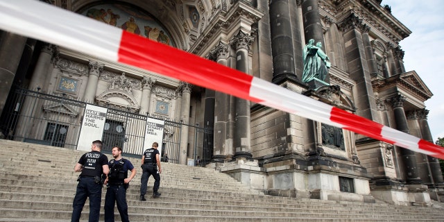 Police officers stay in front of the Berlin Cathedral in Berlin, Germany, Sunday, June 3, 2018.