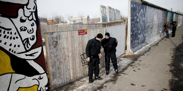 March 27, 2013: Police officers guard a construction site and sections of the East Side Gallery, while parts of the former Berlin Wall are removed in Berlin, Germany. Work crews backed by about 250 police have removed portions of the Berlin Wall known as the East Side Gallery to make way for an upscale building project, despite demands by protesters that the site be preserved. Plans to remove part of the 3/4-mile stretch of wall sparked protests that developers were sacrificing history for profit.