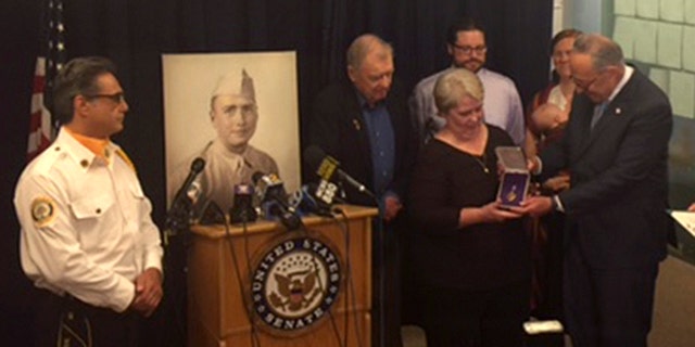 Sen. Charles Schumer of New York presents lost Purple Heart to family of World War II Staff Sgt. Bernard J. McNamara at press conference Sunday.