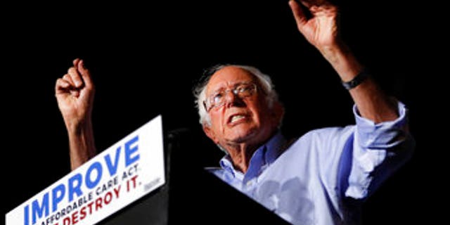 In this July 9, 2017 photo, Sen. Bernie Sanders, I-Vt., speaks during a "Care Not Cuts" rally in support of the Affordable Care Act in Covington, Ky. House Minority Leader Nancy Pelosi is declining to endorse Sen. Bernie Sanders' universal health care bill saying that while she has long supported the idea the bill captures, of everybody getting health coverage, "Right now I'm protecting the Affordable Care Act." (AP Photo/John Minchillo)