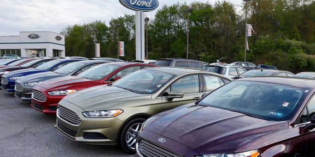 In this Wednesday, May 8, 2013 photo, new 2013 Ford Fusions are seen at an automobile dealer in Zelienople, Pa. U.S. auto sales slowed slightly in June 2014 but still maintained a healthy pace despite a record-setting string of safety recalls at General Motors and a slowdown in truck sales at Ford. Ford's U.S. sales chief John Felice said sales picked up at the end of June as automakers started promoting Independence Day sales. (AP Photo/Keith Srakocic)