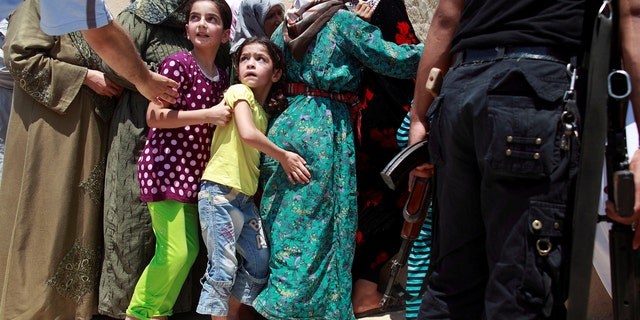 Girls queue to buy bread at the only bakery serving the outskirts of Idlib province, Syria August 1, 2012.