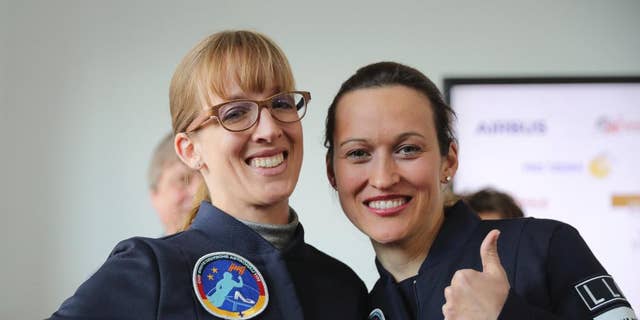 Insa Thiele-Eich, left, and  Nicola Baumann give a thumb up sign in Berlin, Wednesday, April 19, 2017. A fighter pilot and a meteorologist have made the finals in the race to become Germany’s first female astronaut. A panel of experts picked the two finalists - German air force Eurofighter jet pilot Maj. Nicola Baumann and meteorologist Insa Thiele-Eich - from the top six candidates.  (Michael Kappeler/dpa via AP)