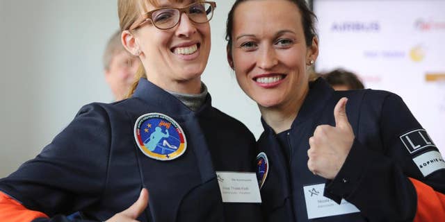 Insa Thiele-Eich, left, and Nicola Baumann give a thumb up sign in Berlin, Wednesday, April 19, 2017. A fighter pilot and a meteorologist have made the finals in the race to become Germany’s first female astronaut. A panel of experts picked the two finalists - German air force Eurofighter jet pilot Maj. Nicola Baumann and meteorologist Insa Thiele-Eich - from the top six candidates. (Michael Kappeler/dpa via AP)