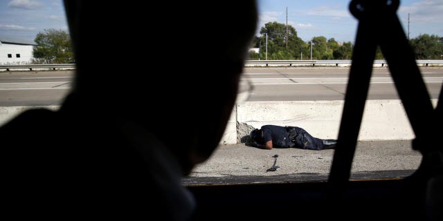 A police officer involved in an accident lies on the ground as President Trump's motorcade travels past him in Indianapolis, Sept. 27, 2017.