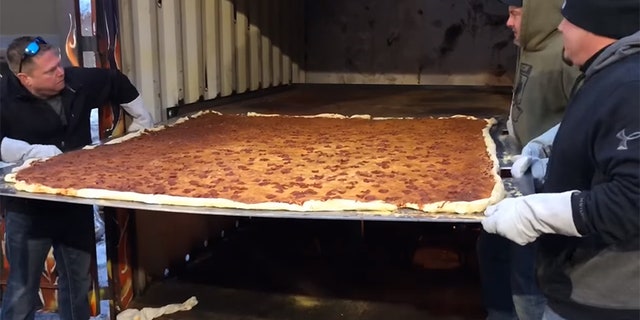 The six-foot-by-six-foot square pizza clocked in at 100 pounds of crust, sauce, cheese and pepperoni.