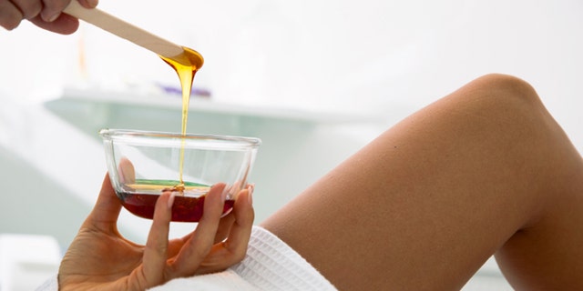Beautician prepares wax for a beauty treatment.
