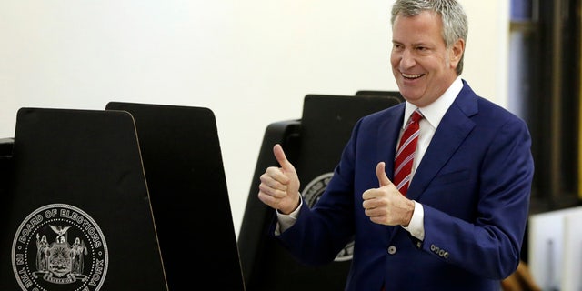 In this Nov. 7, 2017 photo, New York Mayor Bill de Blasio signals a double thumbs-up after voting at the Park Slope Library, in the Brooklyn borough of New York.
