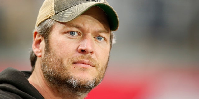 In this Dec. 27, 2015 file photo, singer Blake Shelton watches from the sidelines prior to an NFL football game between the Green Bay Packers and the Arizona Cardinals in Glendale, Ariz.