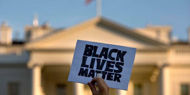 A man holds up a sign saying "Black Lives Matter" during a protest of shootings by police, at the White House in Washington, on July 8, 2016.