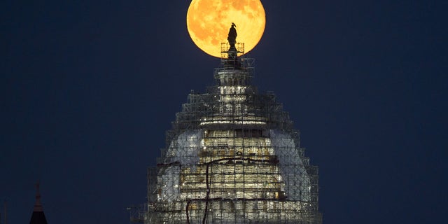 The "blue moon" full moon of July 31, 2015 rises behind the dome the U.S. Capitol in this image from NASA photographer Bill Ingalls.