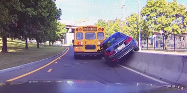 Video captured BMW crashing into construction barrier after nearly striking school bus. (WTEN-TV)