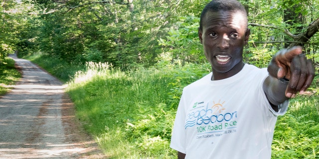 In this July 5, 2017, photo, Moninda Marube points to the house on Whitman Spring Trail in Auburn, Maine, while recounting his encounter with a pair of bears that chased him.