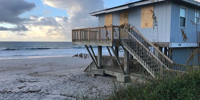A boarded up home on North Topsail Beach in North Carolina as Hurricane Florence approaches in the distance.