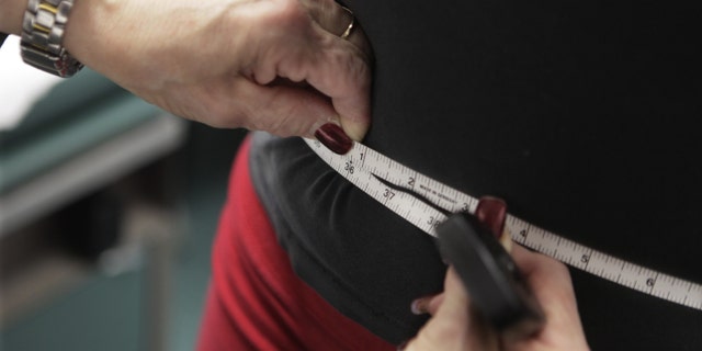 FILE - In this Jan. 20, 2010, file photo, a waist is measured during an obesity prevention study at Rush University Medical Center in Chicago. The bathroom scale may show a good number but how much of that weight is fat, not muscle? New studies are adding to the evidence that the scale doesn't always tell the whole story when it comes to weight-related health risks. (AP Photo/M. Spencer Green, File)
