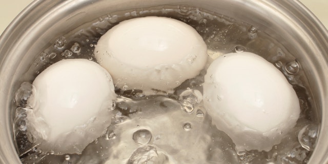 Closeup of three eggs boiling in pot of hot water