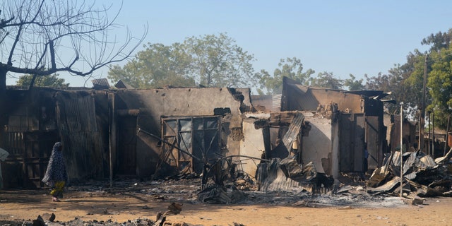 A woman walks past homes destroyed by the Islamist group Boko Haram in Bama, Borno State on Feb. 20, 2014.