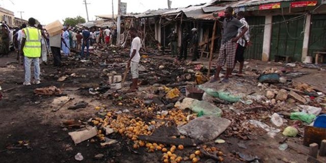 People gather on July 2, 2014, at the scene of a car bomb explosion, at the central market, in Maiduguri, Nigeria, the birthplace of terror group Boko Haram. (AP Photo/Jossy Ola)