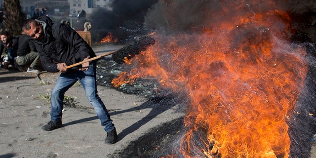 A Palestinian protester burns tires to protest President Trump's decision to move the U.S. Embassy in Israel to Jerusalem.