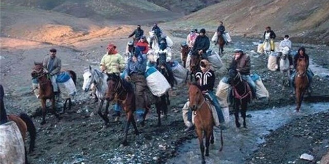 Hundreds of men, on foot and on horseback, haul the contraband booze into Iran, risking their lives in the process.