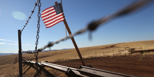 SONOITA, AZ - FEBRUARY 26: An American flag flies at the U.S.-Mexico border on February 26, 2013 near Sonoita, Arizona. The Federal government has increased the Border Patrol presence in Arizona, from some 1,300 agents in the year 2000 ro 4,400 in 2012. The apprehension of undocumented immigrants crossing into the U.S. from Mexico has declined during that time from 600,016 in 2000 to 123,000 in 2012. (Photo by John Moore/Getty Images)