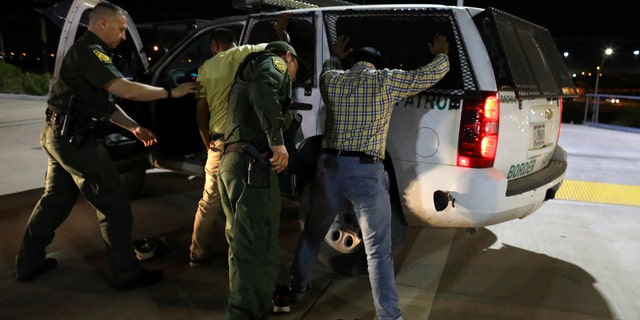 Border patrol agents make an arrest.