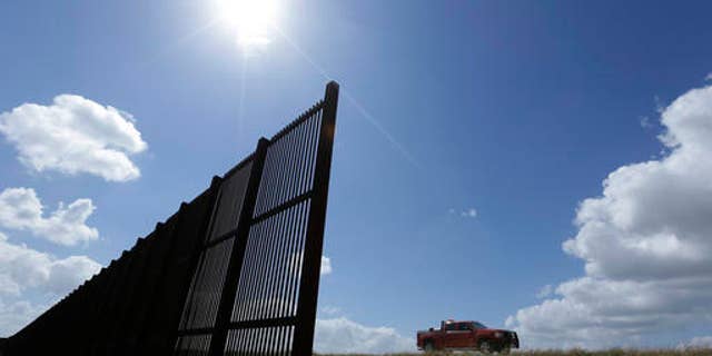 FILE - In this Sept. 6, 2012, file photo, cotton farmer Teofilo "Junior" Flores drives his truck along the U.S.-Mexico border fence that passes through his property in Brownsville, Texas. President Donald Trumpâs vow to accelerate construction of a âcontiguous, physical wallâ along the Mexican border is slamming into a Washington reality _ whoâs going to pay for it and how? (AP Photo/Eric Gay, File)