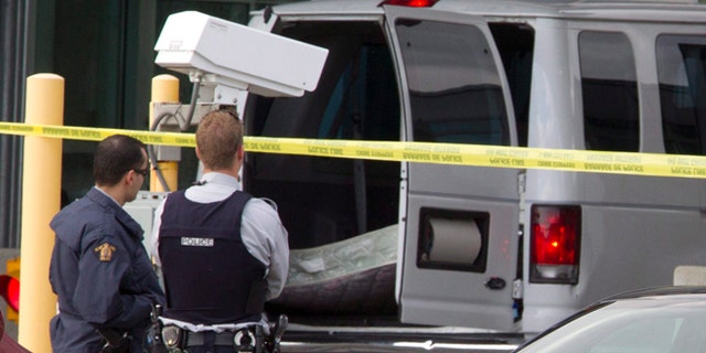 Oct. 16, 2012: Police investigate a van at the scene of a shooting at the Blaine, Wash./Surrey, British Columbia border crossing in Surrey.