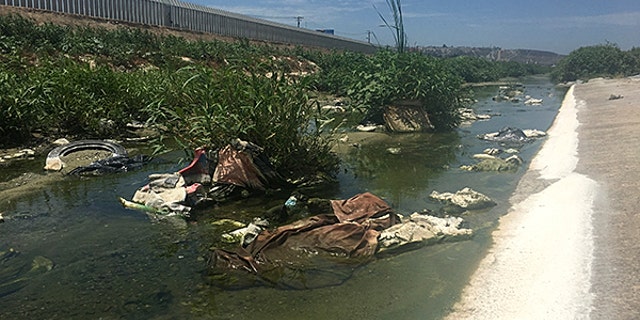 The Tijuana River, polluted with raw sewage, debris, and toxic waste and chemicals, flows into the ocean.