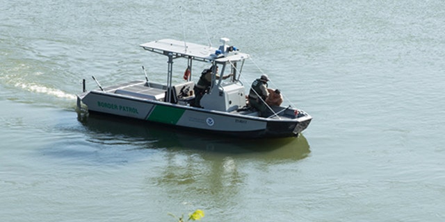 Border Patrol agents pull a man from the Rio Grande into their patrol boat near Roma, Texas Tuesday, April 18, 2017.
