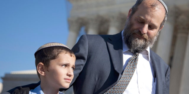 Nov. 7, 2011: Ari Zivotofsky, right, stands with his nine-year-old son, Menachem, outside the Supreme Court in Washington.