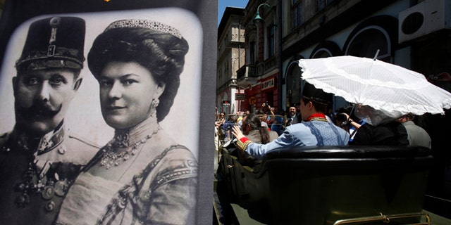 June 28, 2014: Tourists pose for photos inside a replica of the "Graf & Stift" car, parked in front of a museum at the historical street corner in downtown Sarajevo, where Gavrilo Princip assassinated Austro-Hungarian heir to the throne Archduke Franz Ferdinand, in Sarajevo.