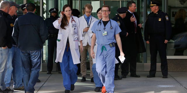 Jan. 20, 2015: Medical personnel walk past law enforcement officials, right, as they depart the Shapiro building at Brigham and Women's Hospital, in Boston.