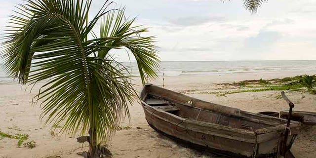 A boat, which members of the Mexican Navy and local villagers say was abandoned by people smugglers transporting Cubans to the Yucatan peninsula, lies on a beach in the community of Cuyo on the Yucatan peninsula October 10, 2007. Record numbers of Cubans are now using Mexico as their route to the U.S. instead of the Straits of Florida. Cubans, unlike other Latino migrants, just have to request political asylum to be allowed to enter the U.S. legally. Picture taken October 10, 2007. REUTERS/Victor Ruiz (MEXICO) - RTR1UTGY