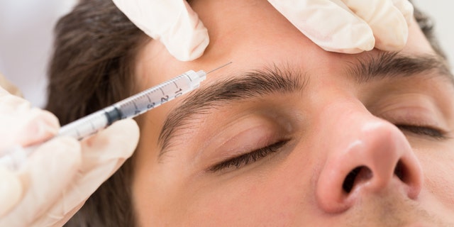Young Man Having Botox Treatment At Beauty Clinic