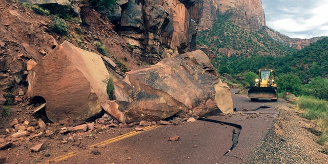 This Wednesday, Aug. 10, 2016 photo provided by the National Park Service shows the Zion- Mount Carmel Highway, State Route 9 closed, in Zion National Park after a boulder tumbled onto the roadway.