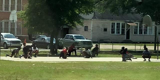 A group of teens dropped to their knees in Franklinton, Louisiana, when they saw a funeral procession passing by.