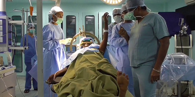This is the incredible moment brain surgeons 'burned' a part of a Parkinson's sufferer's BRAIN - instantly stopping her debilitating tremors.