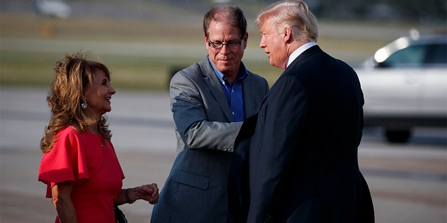 President Trump talks with Indiana Republican Senate candidate Mike Braun, center, and his wife Maureen Braun after arriving at Evansville Regional Airport on Thursday in Evansville, Ind.