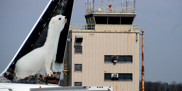 FILE - In this April 8, 2013, file photo, the painted tail appears on a Frontier Airlines aircraft parked at a gate at Trenton-Mercer Airport in Ewing, N.J. Four women pilots who fly for Frontier want the airline to change policies on maternity leave and make it easier for new mothers to pump breast milk once they have returned to work. The American Civil Liberties Union has filed discrimination charges with the Equal Employment Opportunity Commission on behalf of the four. (Jackie Schear/The Trentonian via AP) TRENTON TIMES OUT; PHILLY METRO OUT; MANDATORY CREDIT