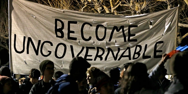Protestors against a scheduled speaking appearance by polarizing Breitbart News editor Milo Yiannopoulos march on the University of California at Berkeley campus Wednesday, Feb. 1, 2017, in Berkeley, Calif. The event was canceled out of safety concerns after protesters hurled smoke bombs, broke windows and started a bonfire. (AP Photo/Ben Margot)