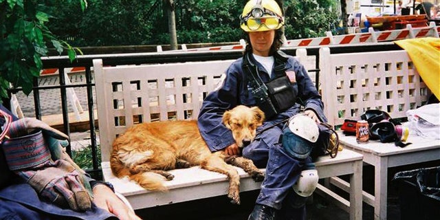 In this undated photo, search dog Bretagne rests alongside handler Denise Corliss while searching Ground Zero after the 9/11 attacks