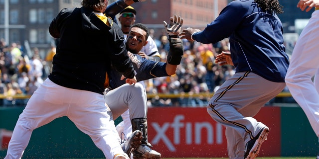 Pittsburgh Pirates' Travis Snider, left, takes down Milwaukee Brewers' Carlos Gomez as Brewers' Rickie Weeks, right, joins a skirmish between the two teams during the third inning of a baseball game in Pittsburgh, Sunday, April 20, 2014. Gomez and Snider were ejected from the game. (AP Photo/Gene J. Puskar)