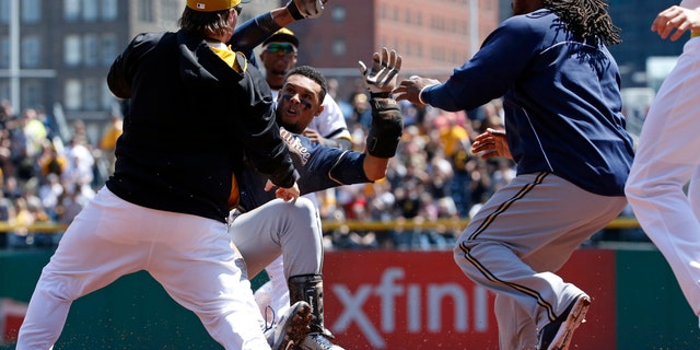 Pittsburgh Pirates' Travis Snider, left, takes down Milwaukee Brewers' Carlos Gomez as Brewers' Rickie Weeks, right, joins a skirmish between the two teams during the third inning of a baseball game in Pittsburgh, Sunday, April 20, 2014. Gomez and Snider were ejected from the game. (AP Photo/Gene J. Puskar)